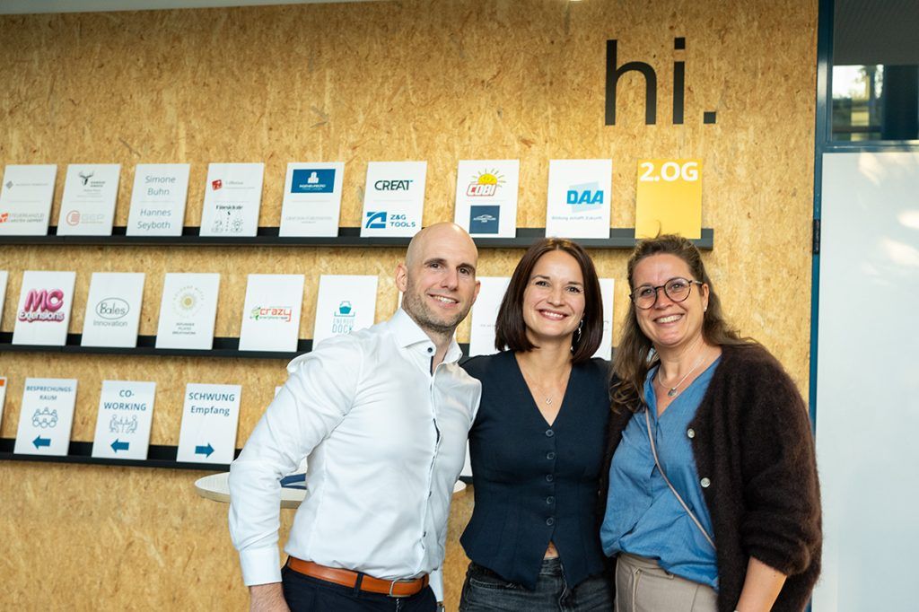 Drei Gäste vor der Infowand bei „Business, Bier & Brezn“